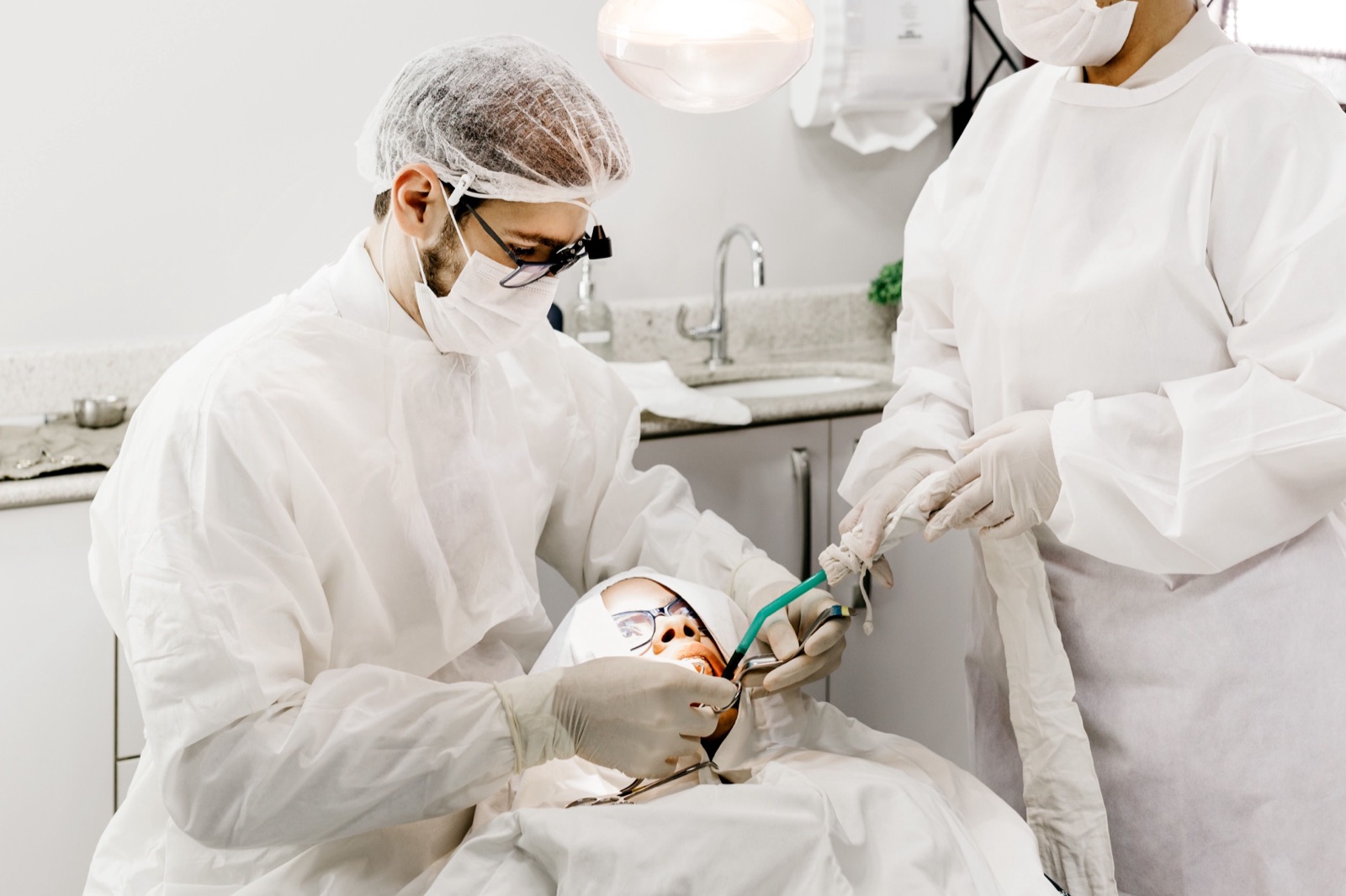 Dentist and assistant treating a patient together